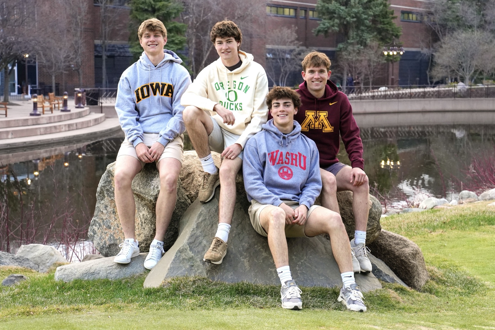 Four friends in college hoodies at a grad-party mini session