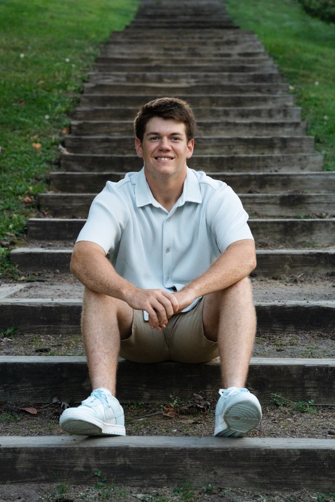 Senior seated on stone park steps in warm evening light